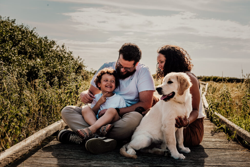 Séance photo à Oye-Plage, prise à la réserve naturelle du platier d'oye. photo de famille avec leur chiot golden retriever