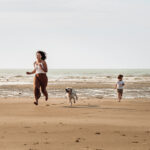 Séance photo à Oye-Plage, prise à la plage. Montrant une famille courant sur le sable avec leur chien golden retriever