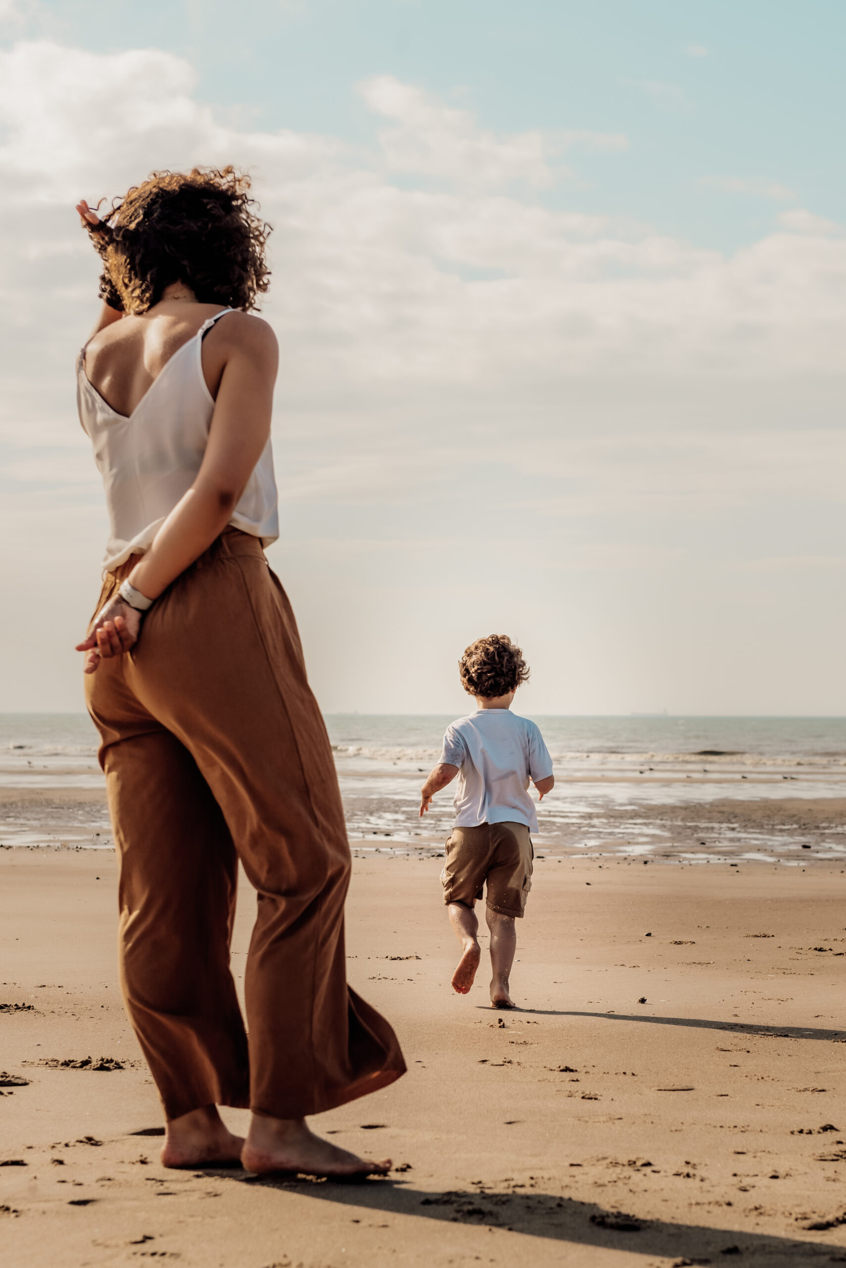 Séance photo à Oye-Plage, prise à la plage. Montrant une maman surveillant son fils qui cours vers l'eau