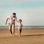 Séance photo à Oye-Plage, prise à la plage. Montrant un papa et son enfant courant sur le sable
