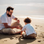 Séance photo à la plage de Oye-Plage, montrant un papa jouant dans le sable avec son enfant