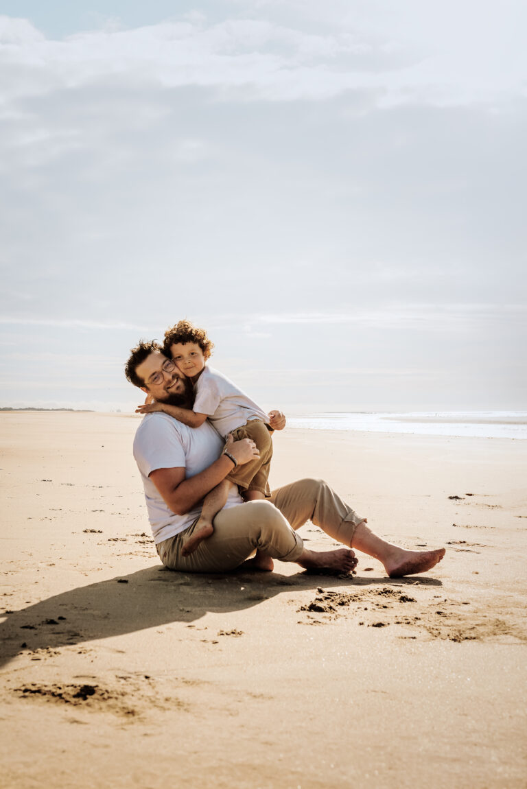Photo prise lors d'une séance photo en famille à Oye-Plage, montrant un petit garçon faisant un calin à son papa
