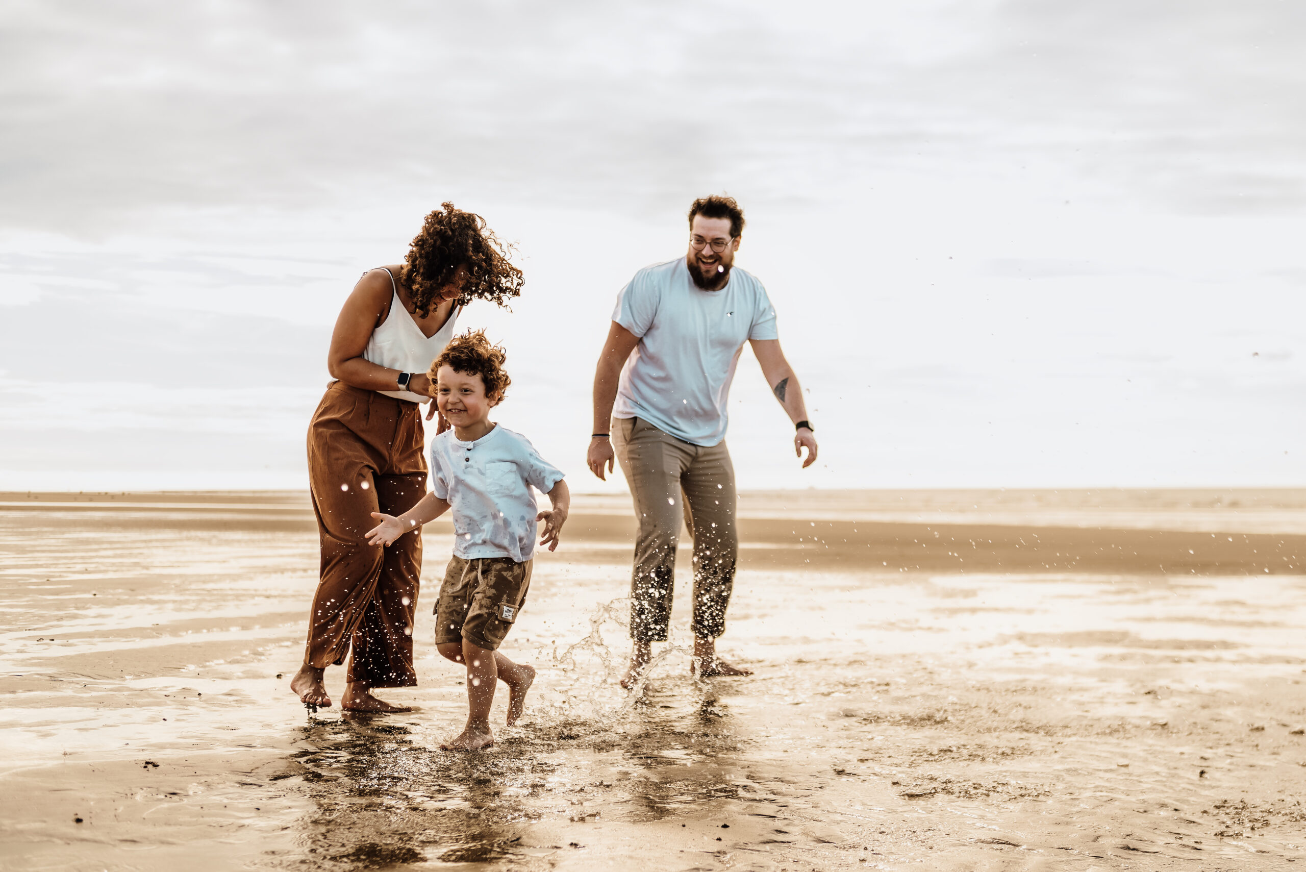Séance photo à Oye-Plage, prise à la plage. Montrant une famille jouant dans l'eau